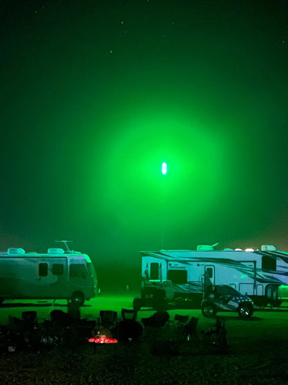 Two RVs parked under a green sky with a bright CAMP LOCATORS.